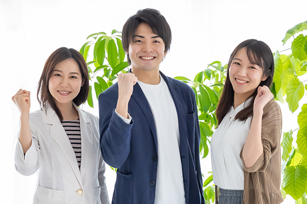 大人３人がガッツポーズをして微笑んでいる。