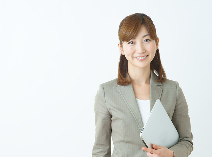 書類を手に笑顔を向ける女性ビジネスマンのイメージ写真