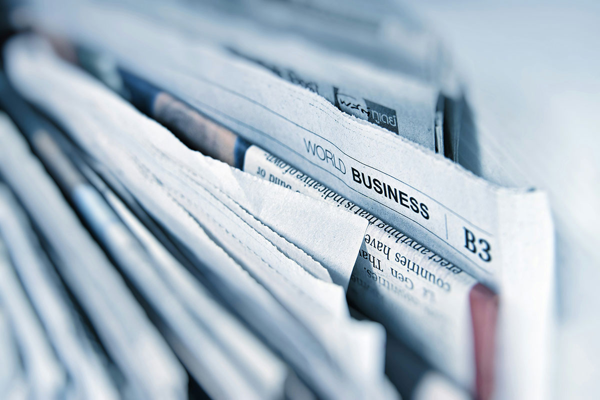 新聞数日分を上からみた写真。world businessと書かれている部分が強調されている。