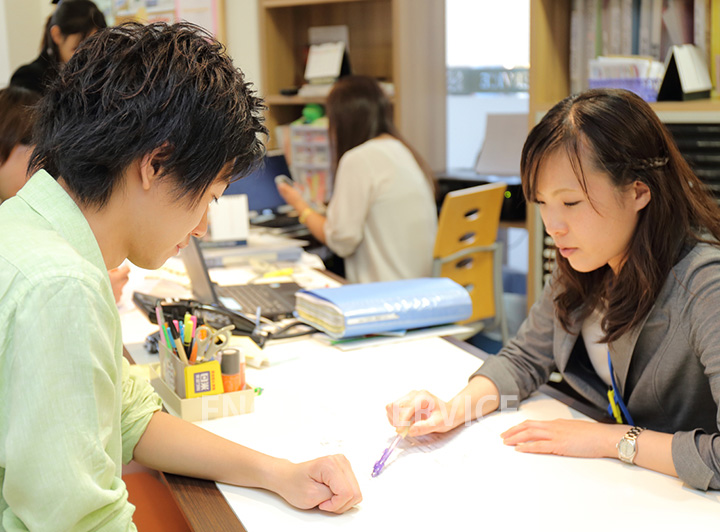 スクールスタッフによるカウンセリングの様子。スタッフがペンで指し示す先を真剣に見つめる受講生。