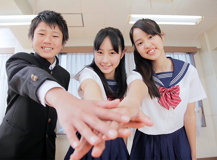 講師からの指導を笑顔でノートにつづる女子高校生のイメージ画像