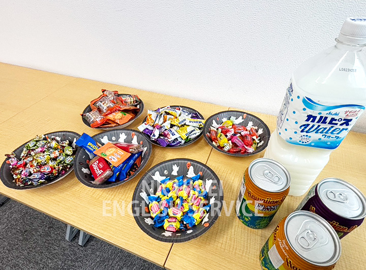 ペットボトル飲料に紙コップ、日本ではあまり見かけない缶ジュースやお菓子が机に並んでいる