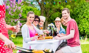 Man grilling meat and vegetables on garden party
