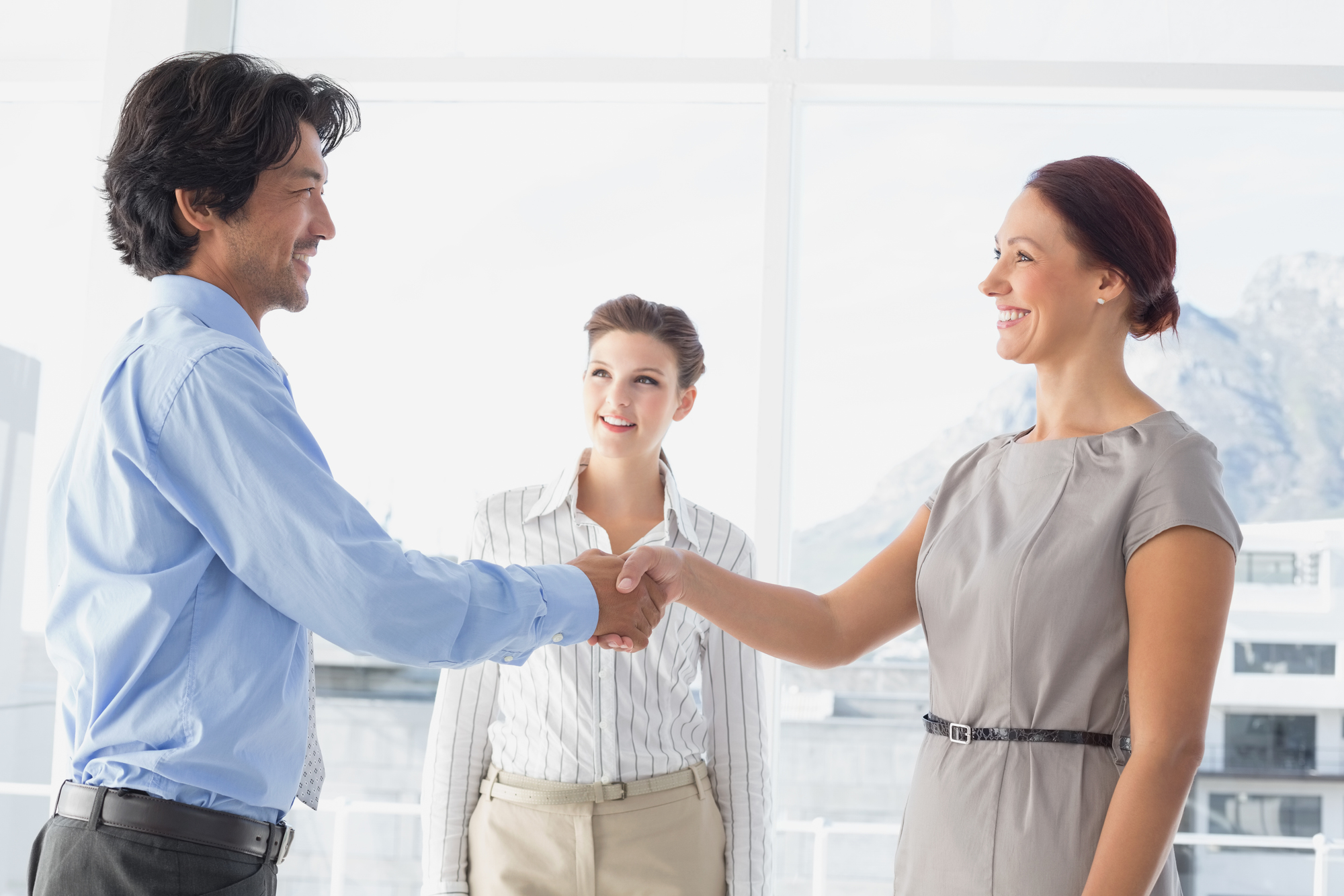 Business man shaking colleagues hand while smiling