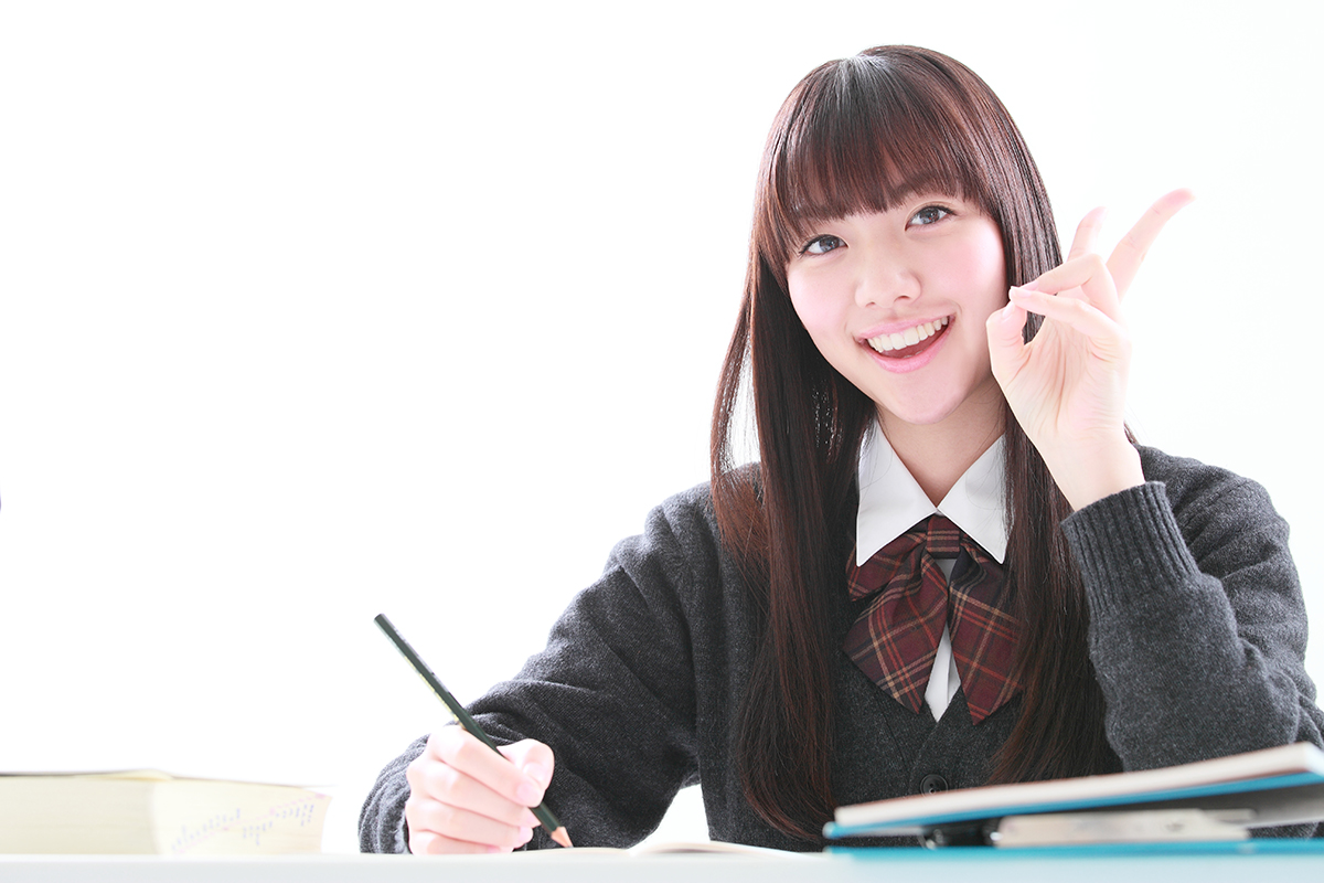 【本文用】笑顔でブイサインをする学習中の女子学生