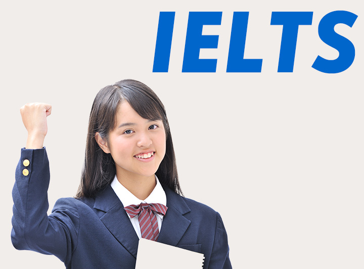 ガッツポーズをとる女子学生とIELTSの文字