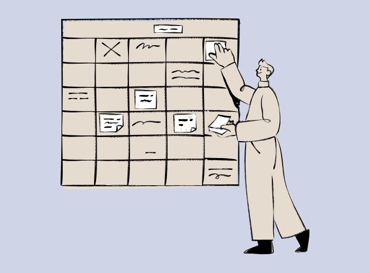 大きなカレンダーにスケジュールを貼る男性のイメージ画像