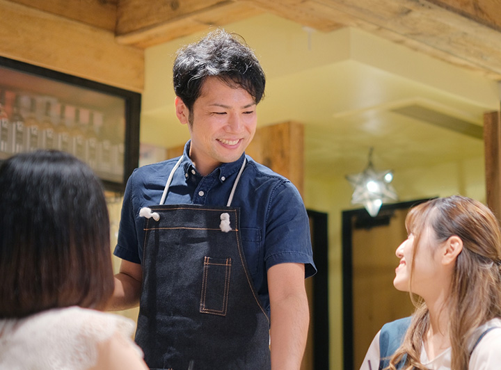 軽食を提供する男性スタッフと受け取る女性客