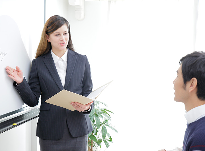 個人レッスンのイメージ。ネイティブと生徒が一緒に笑顔で会話をしている