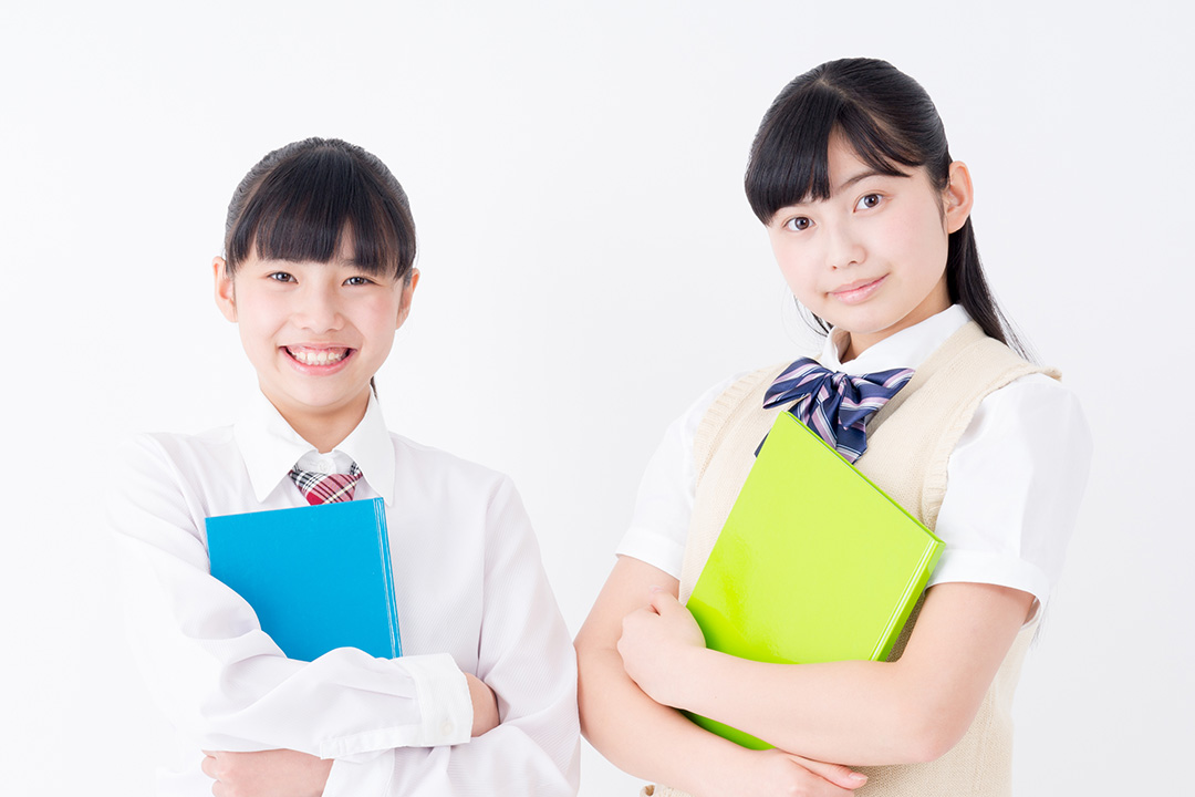 ノートを持って笑顔で学習の準備をしている女子高校生2名のイメージ画像